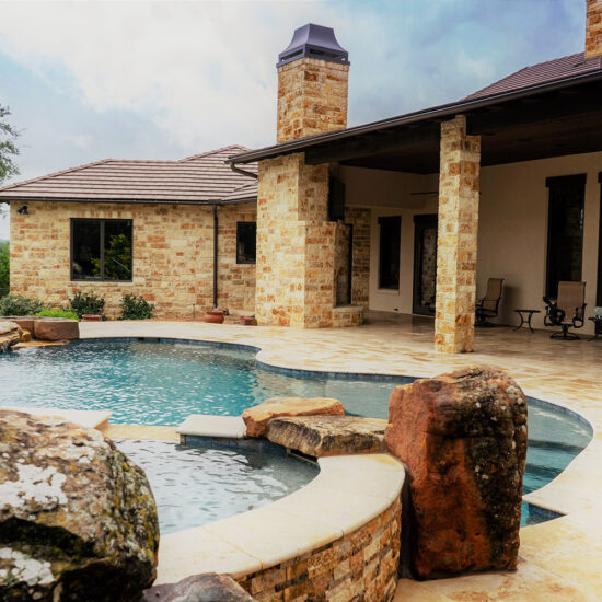 Travertine Beach Entry in this freeform pool design.