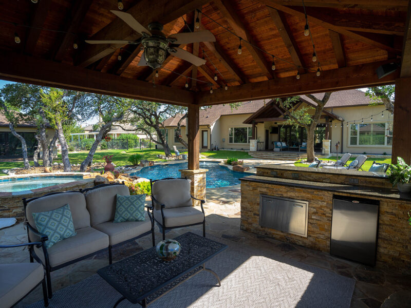 This custom poolscape features a relaxing backyard kitchen and outdoor living space.