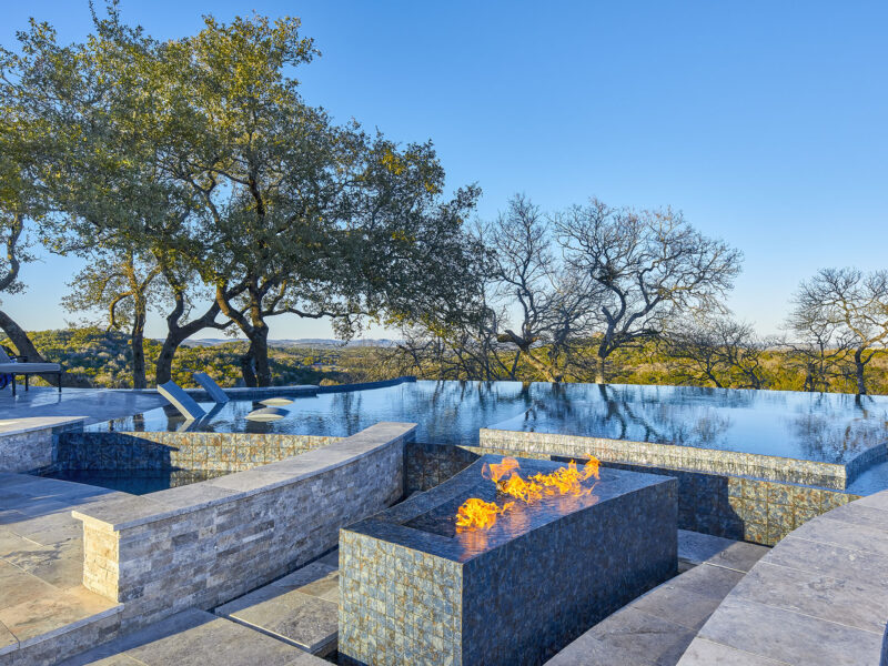 Luxury custom pool with integrated fire feature and natural Hill Country views in North San Antonio by Infinity Pools Texas